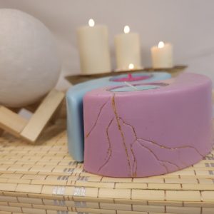 Vela decorativa yin y el yang "Dualidades Encendidas", colección Luces y Sombras. Detalle de resultado de una reparación cuidadosa con una técnica inspirada en el kintsugi japonés: porque hasta la cera rota puede renacer más hermosa.