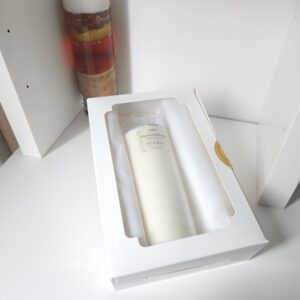 Eseence Mélange - vela aromática dentro de caja blanca con ventana.