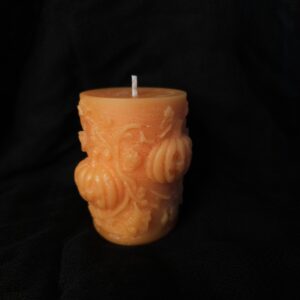 Vela decorativa pilar con calabaza en relieve.