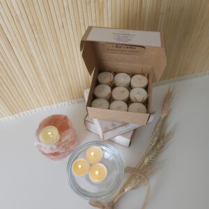 Pack de velas de té flotantes encendidas en agua y fuera del agua y también colocadas en su caja.
